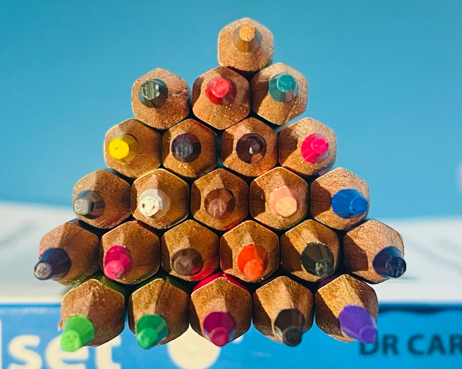 a bunch of colored pencils stacked on top of each other